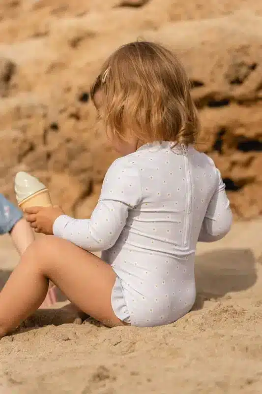 Μακρυμάνικο ολόσωμο μαγιό για κορίτσια Daisy LITTLE DUTCH  Πάμε παραλία! Με αυτό το όμορφο μαγιό, από ανακυκλωμένο πολυεστέρα, είστε έτοιμες για πολύ διασκέδαση στο νερό και στον ήλιο. Είτε σας αρέσει να πηδάτε στα κύματα, είτε απολαμβάνετε να χτίζετε κάστρα από άμμο, αυτό το ολόσωμο μαγιό με μακριά μανίκια θα σας κρατήσει ζεστή στο νερό και προστατευμένη από τον ήλιο. Χάρη στο φερμουάρ στο πίσω μέρος είναι εύκολο να φορεθεί και να αφαιρεθεί ακόμα κι όταν το μικρό σας είναι βρεγμένο και καλυμμένο με άμμο. Το μαγιό είναι κατασκευασμένο από ύφασμα προστασίας UV.  Υλικό : 85% ανακυκλωμένος πολυεστέρας/15% ελαστάνη Οδηγίες πλυσίματος: Πλύσιμο στο πλυντήριο στους 30 βαθμούς, ήπιες στροφές, δεν σιδερώνετε, απαγορεύεται το λευκαντικό. Δεν είναι κατάλληλο για στεγνωτήριο. Προειδοποίηση: ξεπλύνετε με κρύο καθαρό νερό μετά τη χρήση